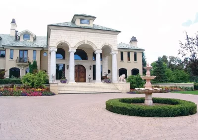front view of luxury estate with fountain, columns and statues
